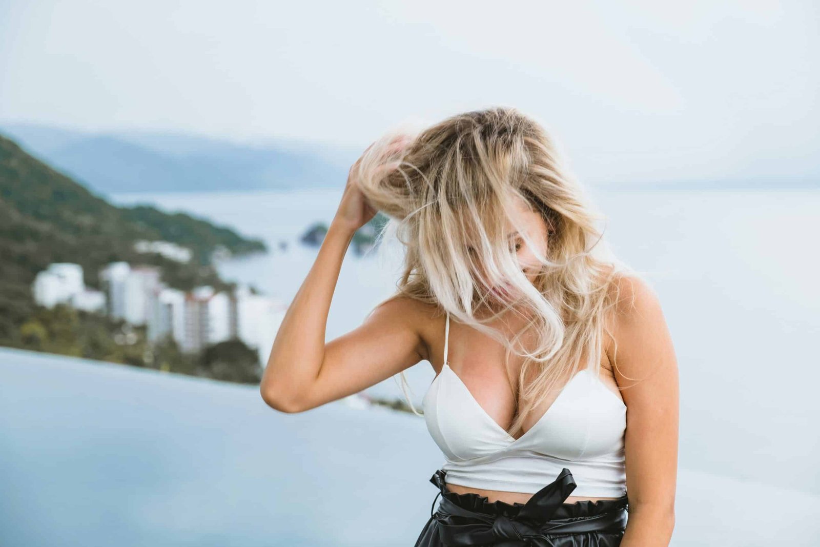 woman in white tank top holding her hair